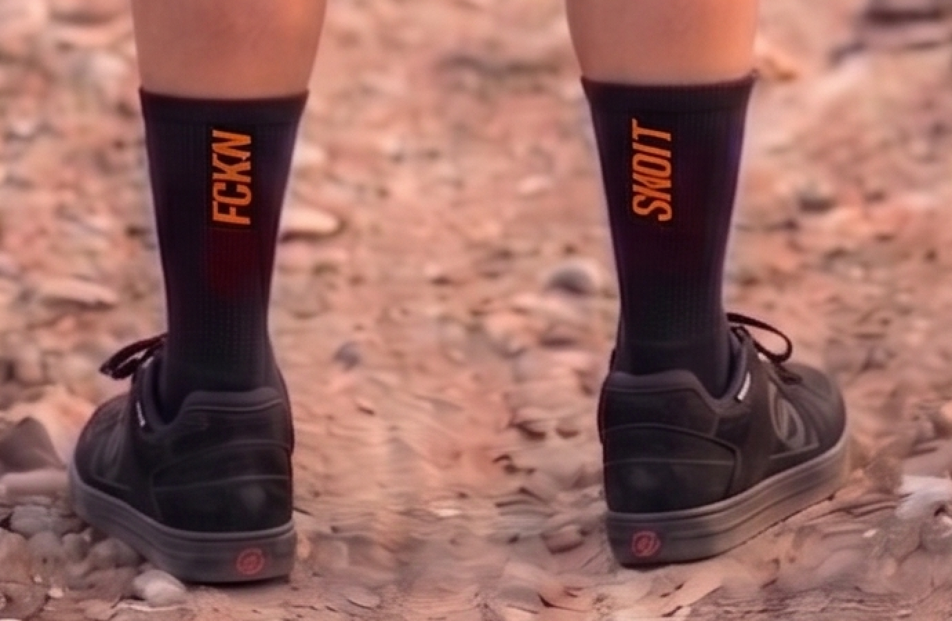 Close-up of black FCKN SNDIT MTB socks by Torq MTB, showing the colorful logo and comfortable fabric for mountain biking.